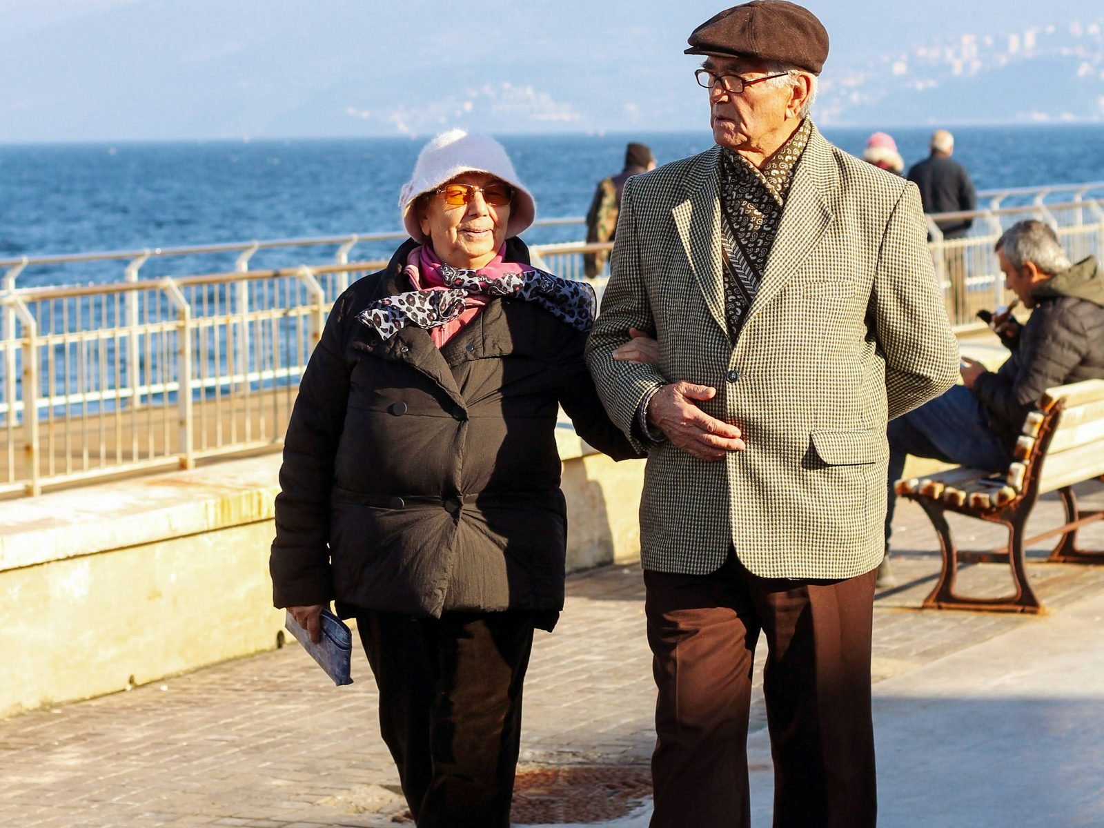 An older couple walking together by the sea