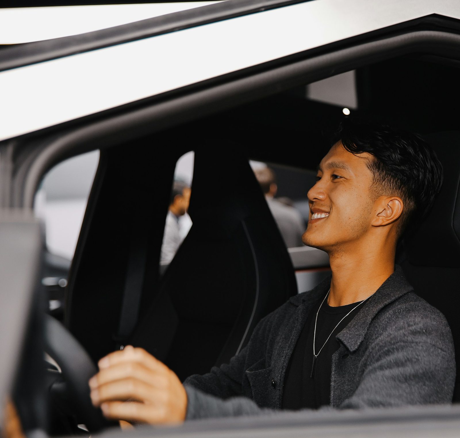 A smiling man in the driver’s seat of his car