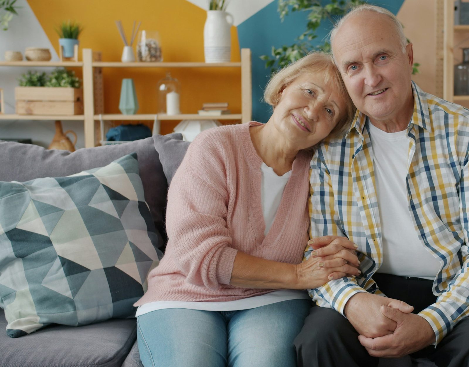An older couple sitting together on their sofa