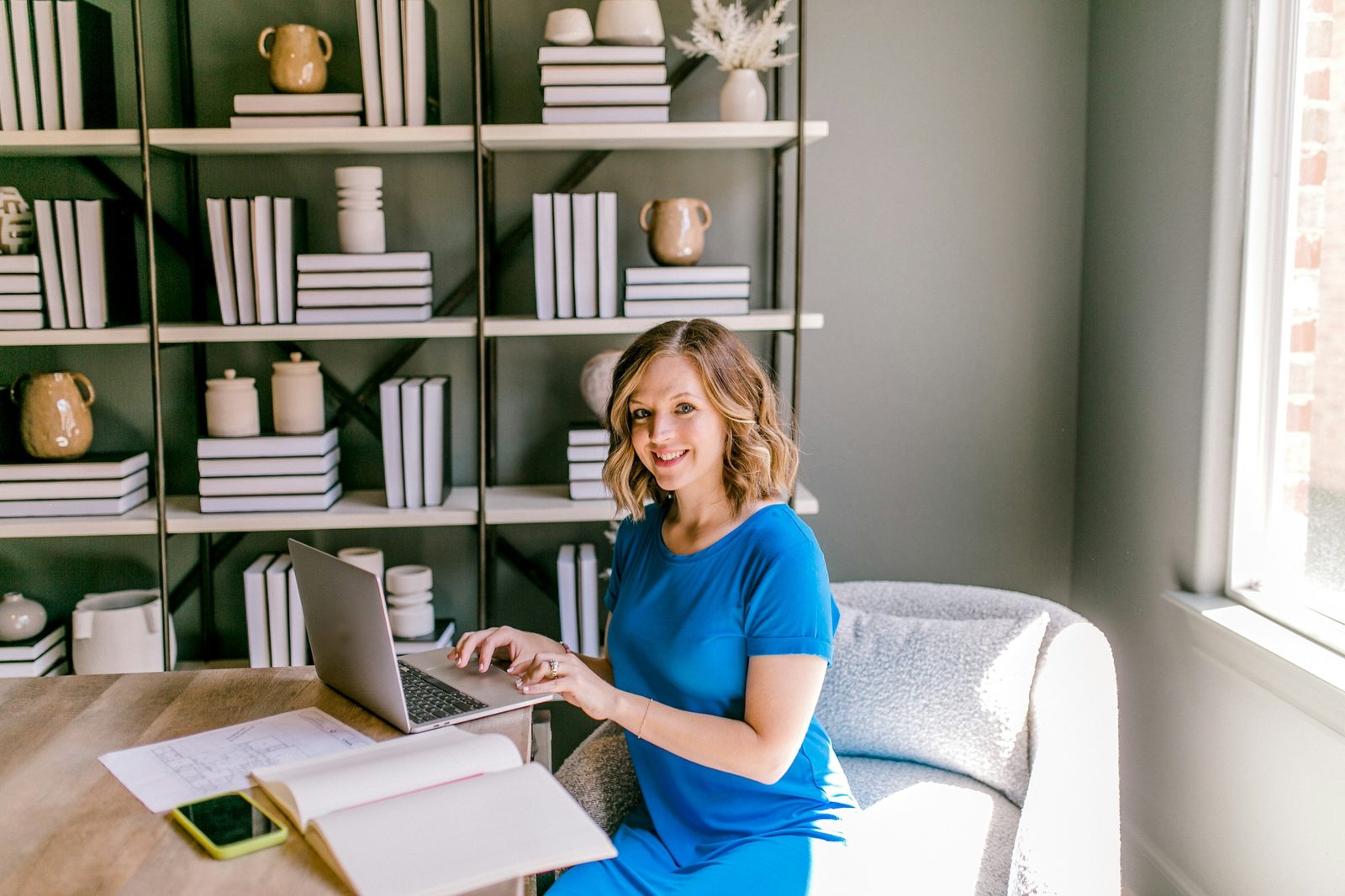 A business owner smiling at her desk with her laptop