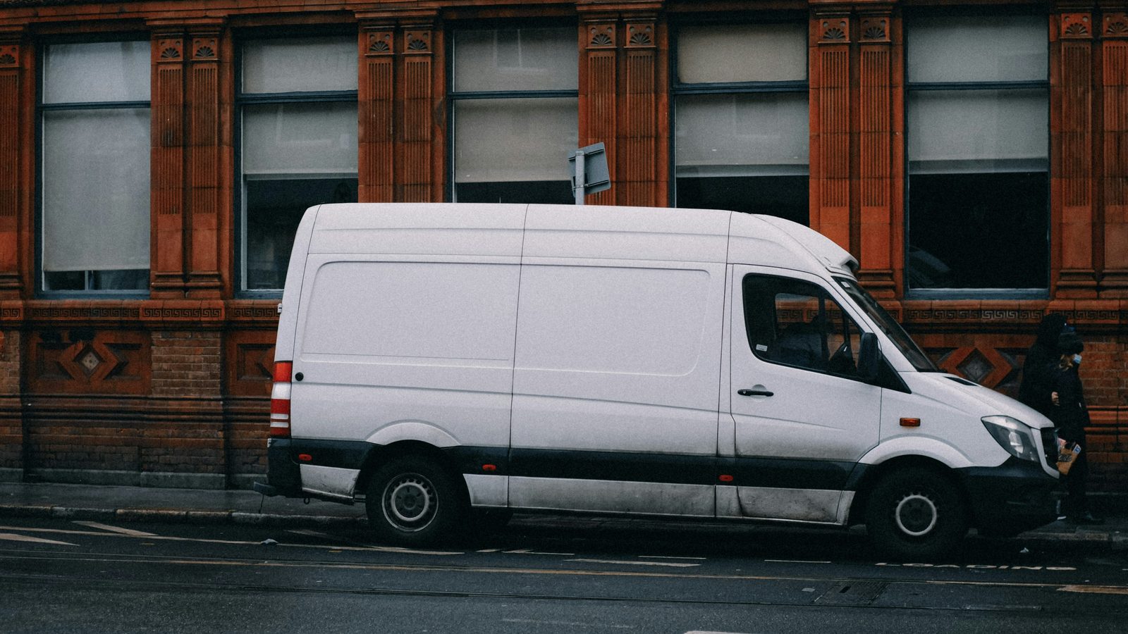 A white work van parked on a city street