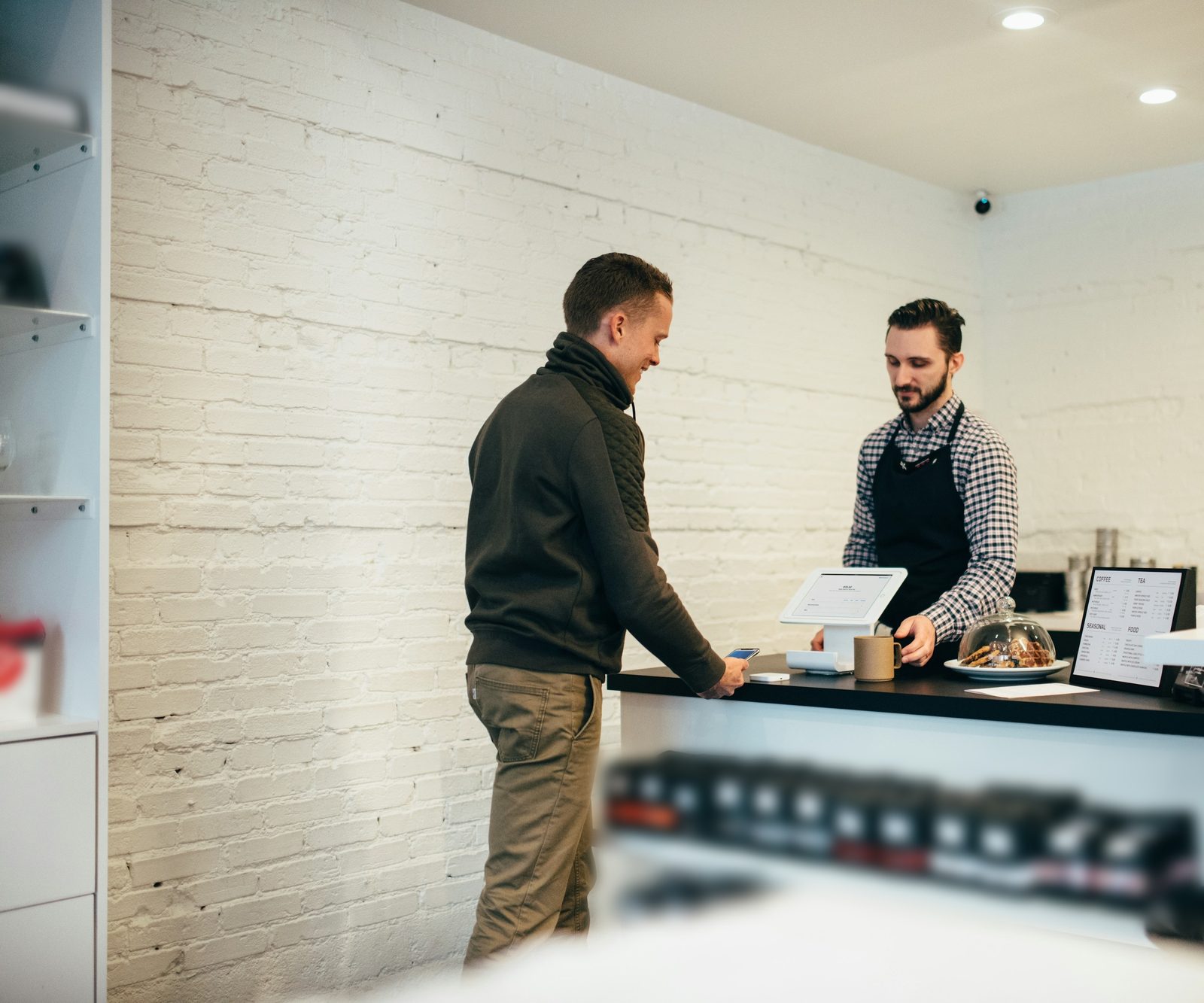 A customer paying at the counter of a small shop