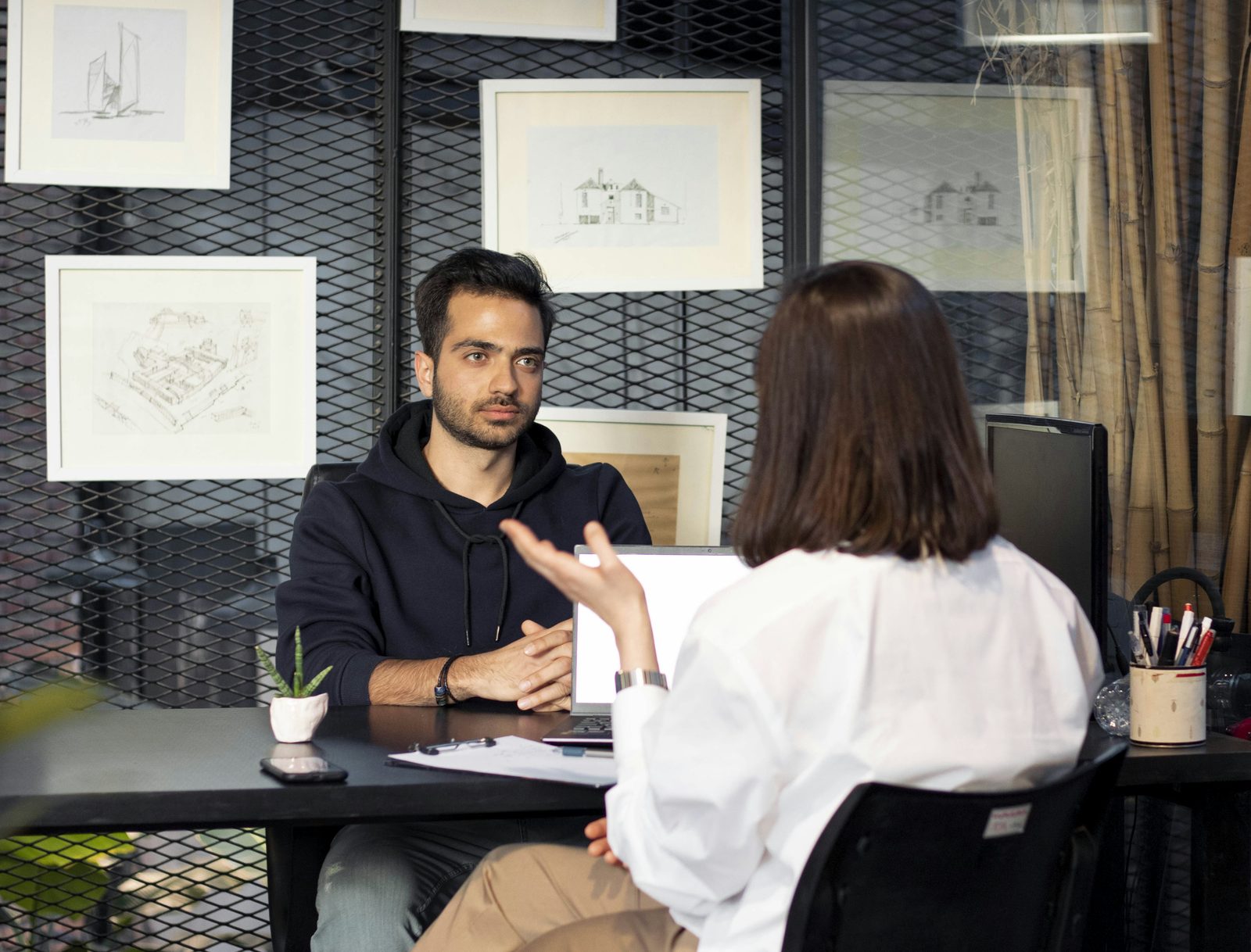 A consultant meeting a client across his desk