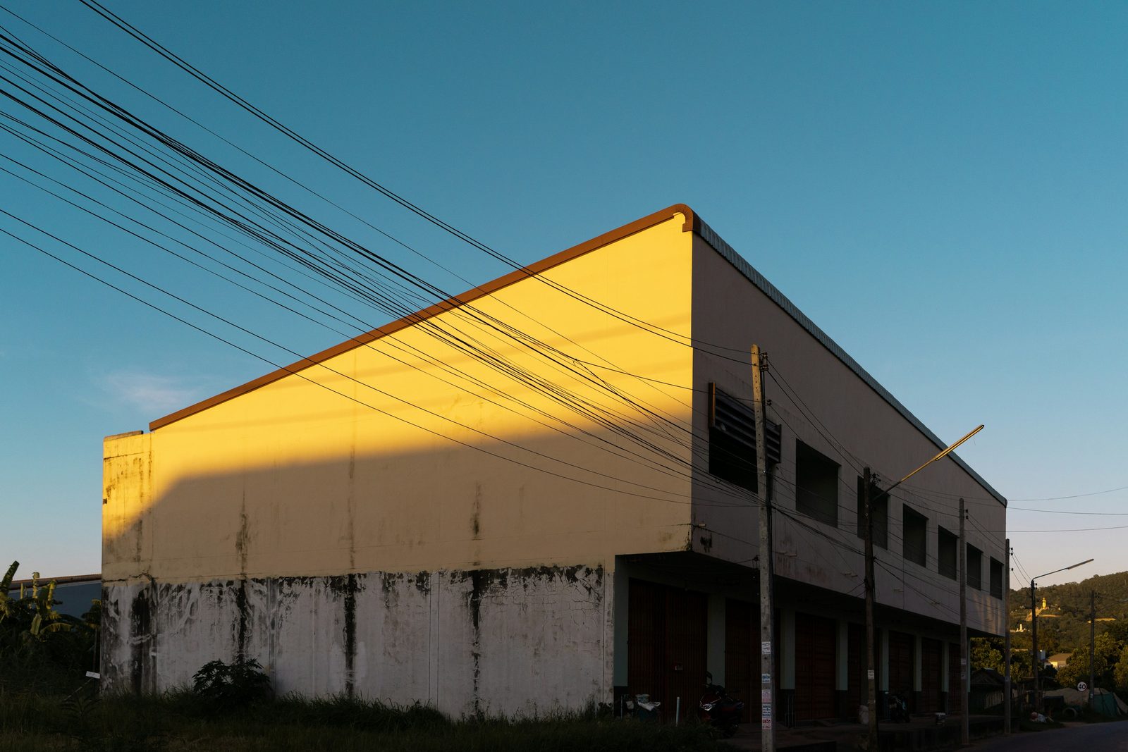 A two-storey commercial building lit by the evening sun