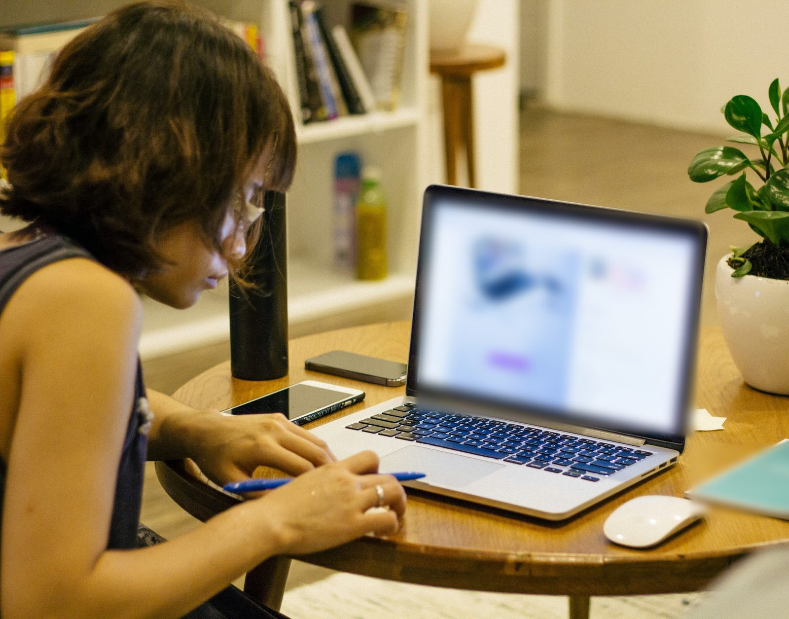 A woman working on a laptop at a cafe table