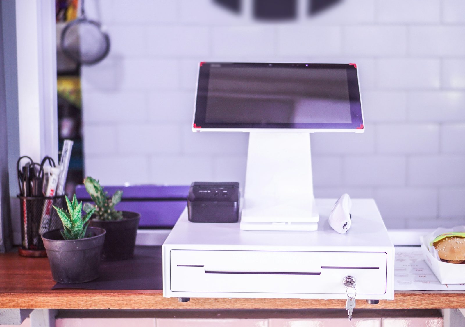 A point-of-sale register and cash drawer on a cafe counter