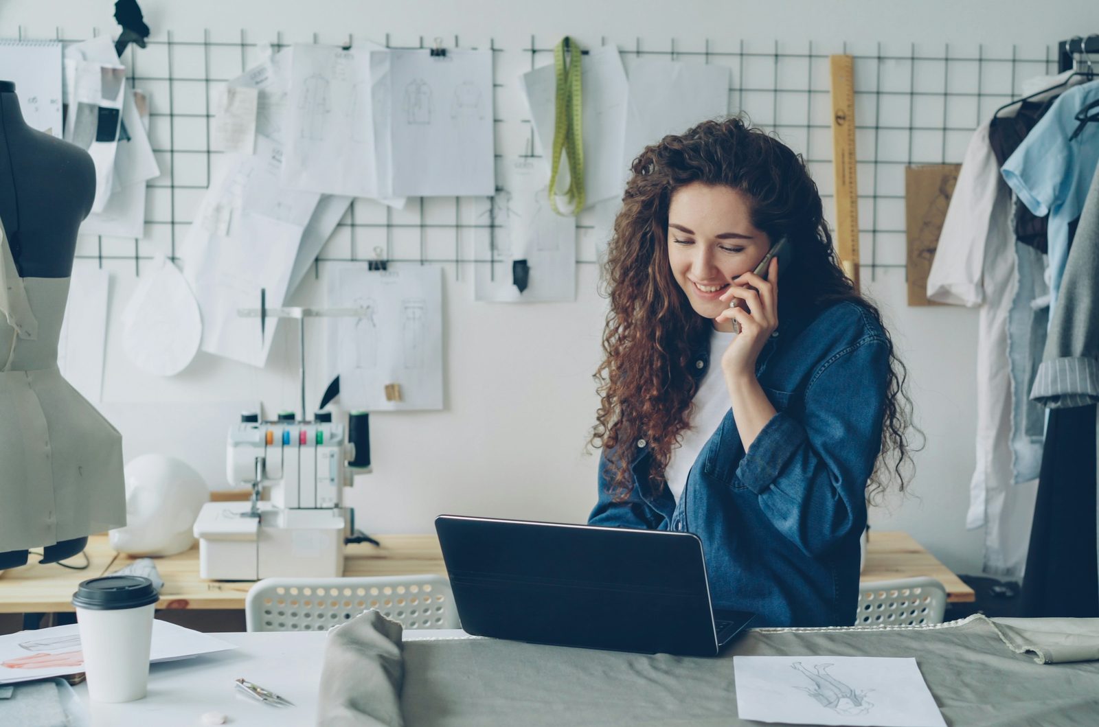 A shop owner on the phone at her laptop in her studio